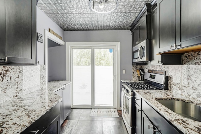 460 Old Town Rd Unit 10A, Port Jefferson Station, NY 11776 - kitchen featuring appliances with stainless steel finishes, decorative backsplash, light stone counters, and an ornate ceiling