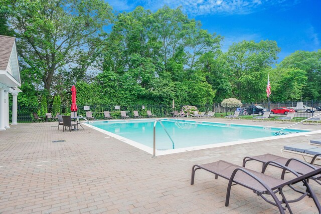 460 Old Town Rd Unit 10A, Port Jefferson Station, NY 11776 - community pool with a patio and view of wooded area