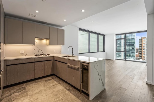 133-36 37th Ave Unit 11H, Flushing, NY 11354 - kitchen featuring white gas stovetop, a peninsula, gray cabinets, light countertops, and recessed lighting