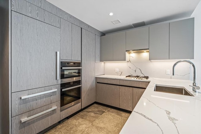 133-36 37th Ave Unit 11H, Flushing, NY 11354 - kitchen with gray cabinetry, light stone counters, and stainless steel appliances