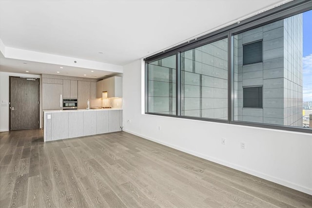 133-36 37th Ave Unit 11H, Flushing, NY 11354 - unfurnished living room with wood finished floors and recessed lighting