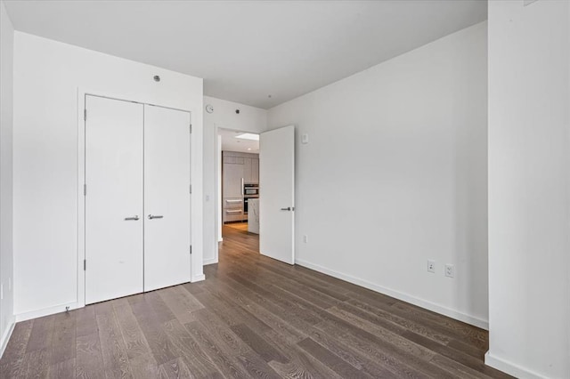 133-36 37th Ave Unit 11H, Flushing, NY 11354 - unfurnished bedroom featuring dark wood-style floors and a closet