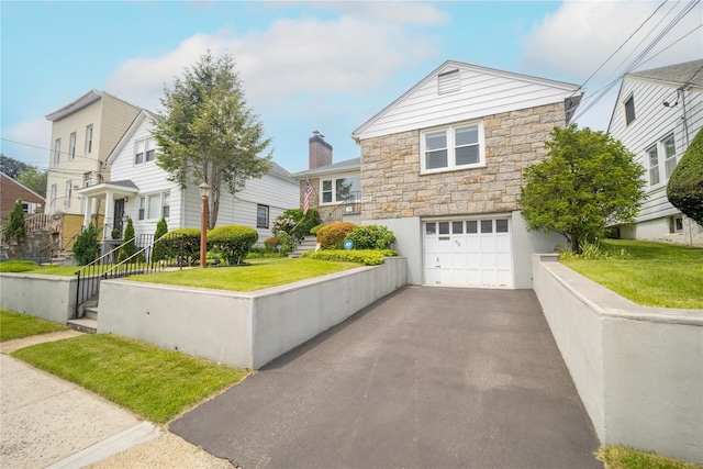 62 Murray Ave, Yonkers, NY 10704 - view of front of house with stone siding, a garage, asphalt driveway, and a front yard