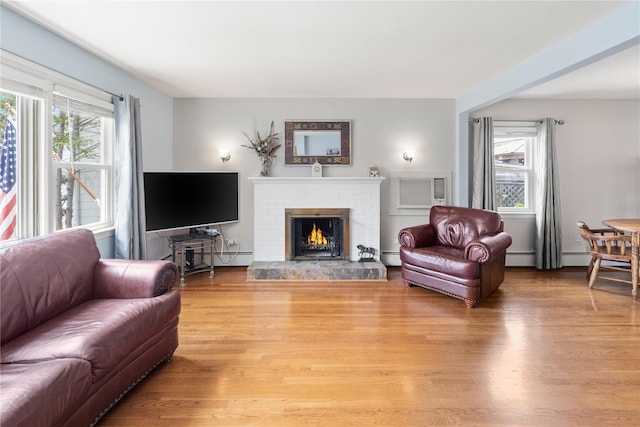 62 Murray Ave, Yonkers, NY 10704 - living area featuring light wood-type flooring, a brick fireplace, and a baseboard heating unit