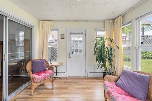 62 Murray Ave, Yonkers, NY 10704 - sunroom / solarium featuring wood finished floors, a baseboard heating unit, healthy amount of natural light, and a textured ceiling