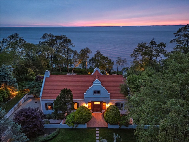215 Hillcrest Dr N, Orient, NY 11957 - view of front facade featuring a tiled roof, a water view, a chimney, and stucco siding