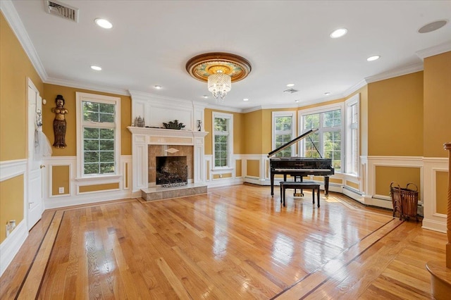 135 Millet St N, Dix Hills, NY 11746 - living area featuring a decorative wall, a tiled fireplace, wainscoting, light wood-type flooring, and ornamental molding