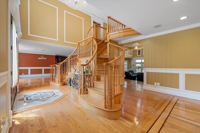 135 Millet St N, Dix Hills, NY 11746 - stairs with a chandelier, a decorative wall, wood finished floors, ornamental molding, and recessed lighting