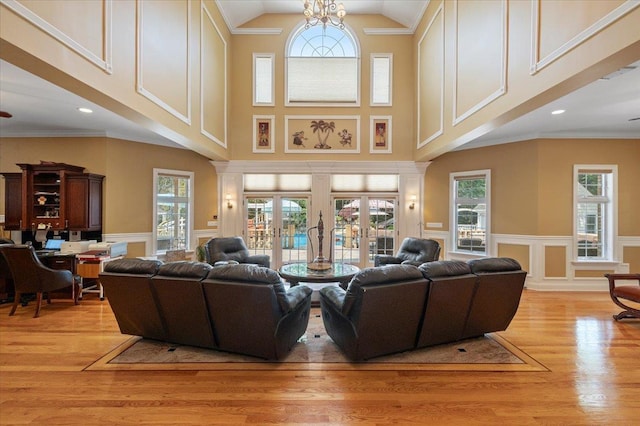 135 Millet St N, Dix Hills, NY 11746 - living area featuring light wood-type flooring, wainscoting, a decorative wall, and high vaulted ceiling