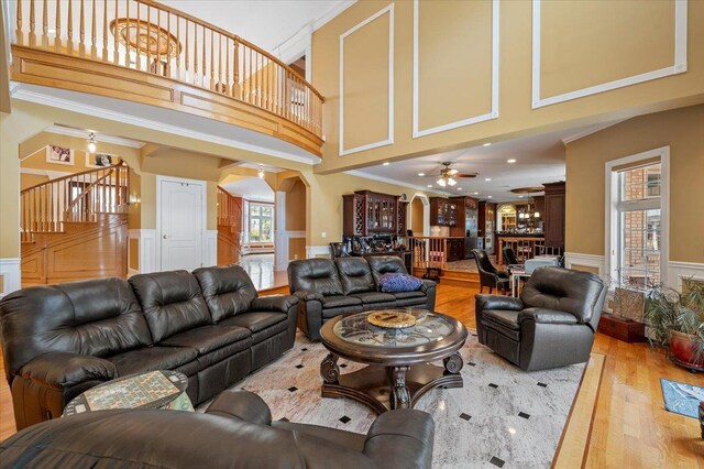 135 Millet St N, Dix Hills, NY 11746 - living area featuring a decorative wall, arched walkways, a wainscoted wall, wood finished floors, and stairway