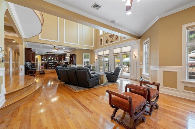 135 Millet St N, Dix Hills, NY 11746 - living area featuring ceiling fan, a decorative wall, light wood-style flooring, ornamental molding, and wainscoting