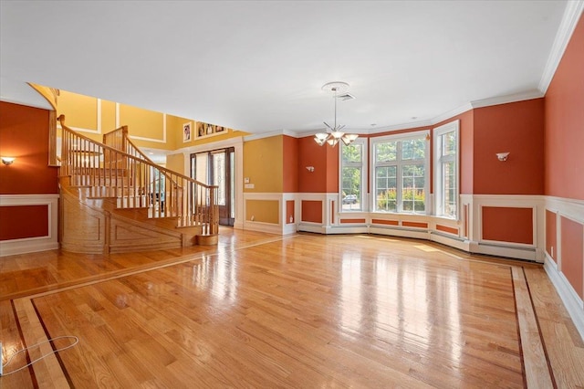 135 Millet St N, Dix Hills, NY 11746 - unfurnished living room with a chandelier, wood finished floors, stairway, a wainscoted wall, and crown molding