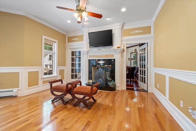 135 Millet St N, Dix Hills, NY 11746 - sitting room featuring healthy amount of natural light, ornamental molding, a fireplace, wood finished floors, and a decorative wall