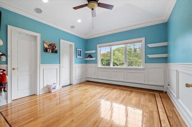 135 Millet St N, Dix Hills, NY 11746 - unfurnished bedroom with baseboard heating, wainscoting, ornamental molding, wood finished floors, and a decorative wall