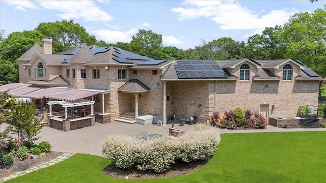 135 Millet St N, Dix Hills, NY 11746 - rear view of house featuring roof mounted solar panels, a lawn, a patio area, and a chimney