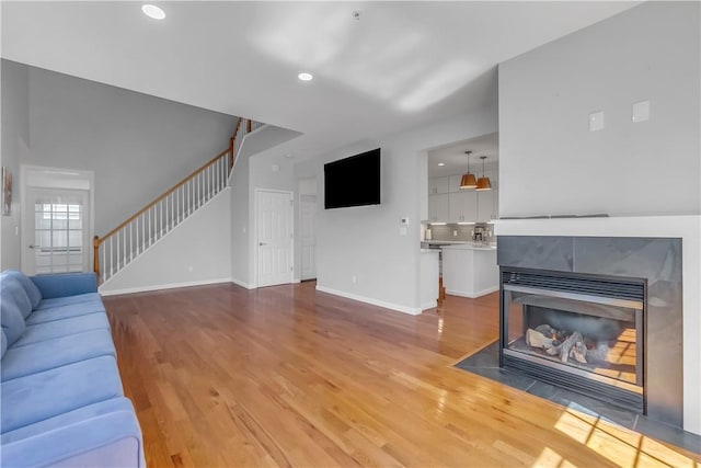1200 Half Moon Bay Dr, Croton-On-Hudson, NY 10520 - unfurnished living room with wood finished floors, stairway, a tile fireplace, and recessed lighting