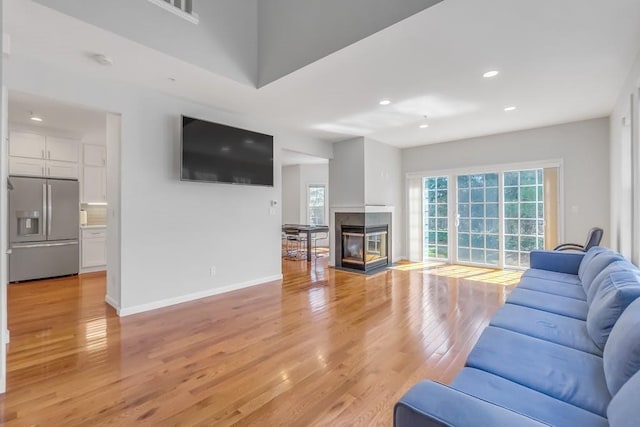 1200 Half Moon Bay Dr, Croton-On-Hudson, NY 10520 - living room featuring light wood finished floors, plenty of natural light, recessed lighting, and a multi sided fireplace