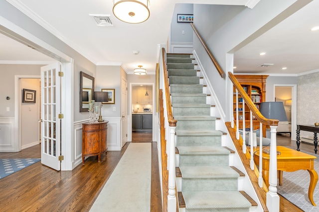 15 Hermitage St, Wading River, NY 11792 - stairway with wood finished floors, ornamental molding, a wainscoted wall, and a decorative wall