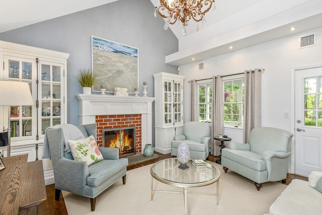 15 Hermitage St, Wading River, NY 11792 - living room with wood finished floors, a chandelier, high vaulted ceiling, plenty of natural light, and a fireplace