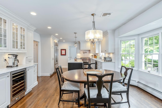 15 Hermitage St, Wading River, NY 11792 - dining area featuring beverage cooler, recessed lighting, wood finished floors, and baseboard heating
