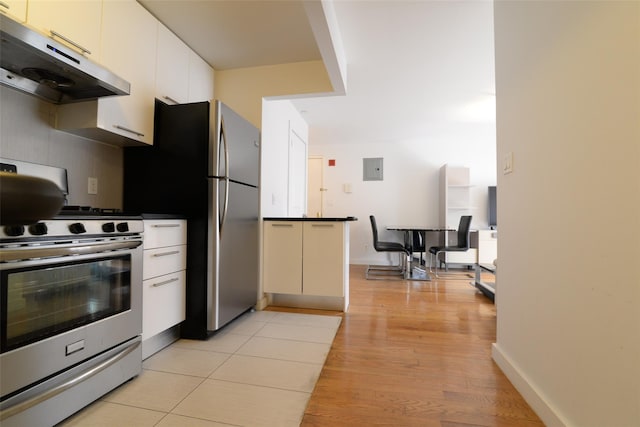132-35 41st Rd Unit 5D, Flushing, NY 11355 - kitchen with under cabinet range hood, appliances with stainless steel finishes, light wood-style flooring, white cabinets, and backsplash
