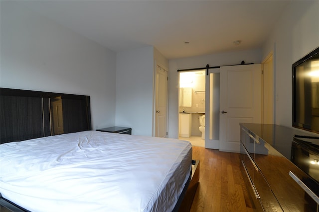 132-35 41st Rd Unit 5D, Flushing, NY 11355 - bedroom featuring wood finished floors, a barn door, and ensuite bath