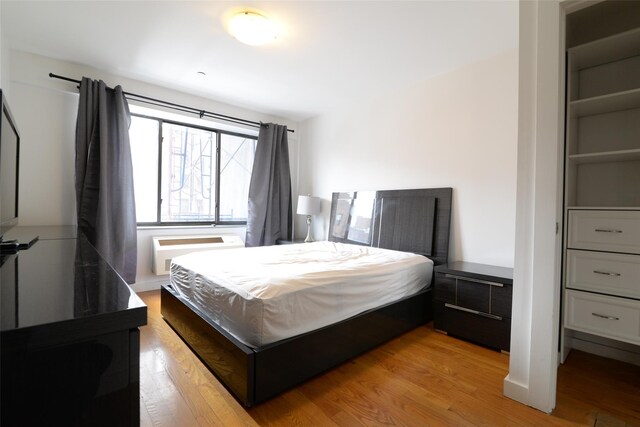 132-35 41st Rd Unit 5D, Flushing, NY 11355 - bedroom with light wood finished floors and a wall unit AC