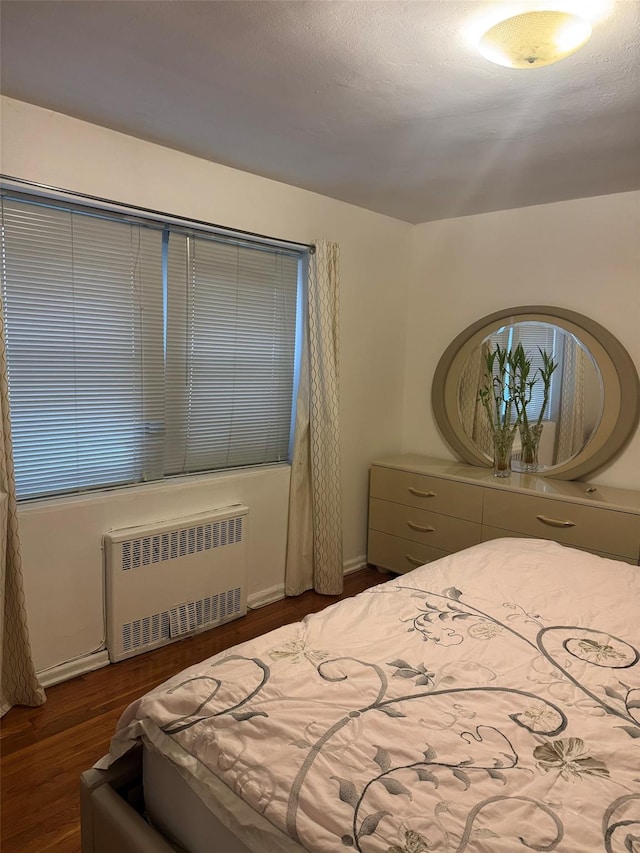 118-60 Metropolitan Ave Unit 1J, Kew Gardens, NY 11415 - bedroom featuring radiator heating unit, wood finished floors, and baseboards