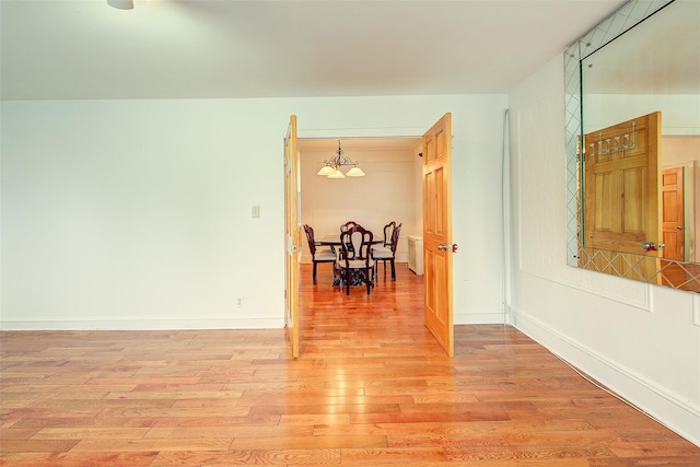 56-20 68th St, Maspeth, NY 11378 - empty room featuring light wood-style flooring and a chandelier