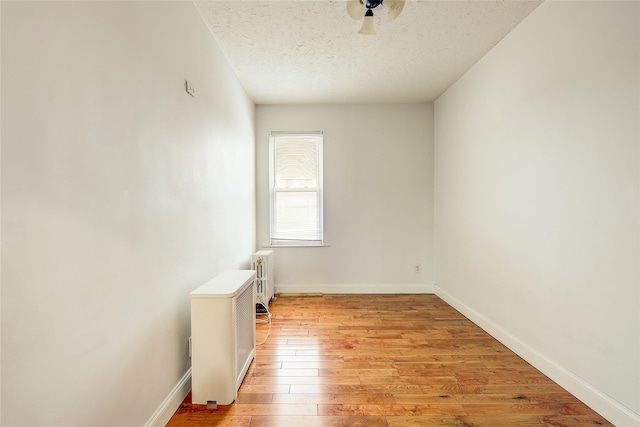 56-20 68th St, Maspeth, NY 11378 - unfurnished room featuring radiator, light wood-type flooring, a textured ceiling, and a ceiling fan