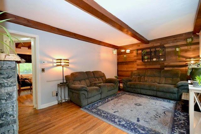 70 Islip Ave, Islip, NY 11751 - living room featuring beam ceiling, wood finished floors, and wood walls