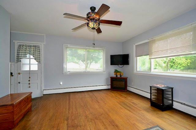 70 Islip Ave, Islip, NY 11751 - spare room with baseboard heating, wood finished floors, and a ceiling fan