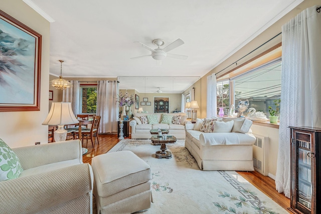 3324 Murdock Ave, Oceanside, NY 11572 - living area with radiator heating unit, wood finished floors, healthy amount of natural light, a ceiling fan, and crown molding