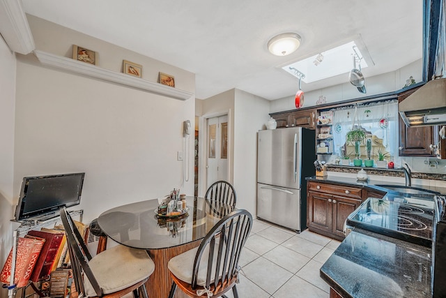 3324 Murdock Ave, Oceanside, NY 11572 - kitchen with freestanding refrigerator, a skylight, light tile patterned floors, electric stove, and dark brown cabinets