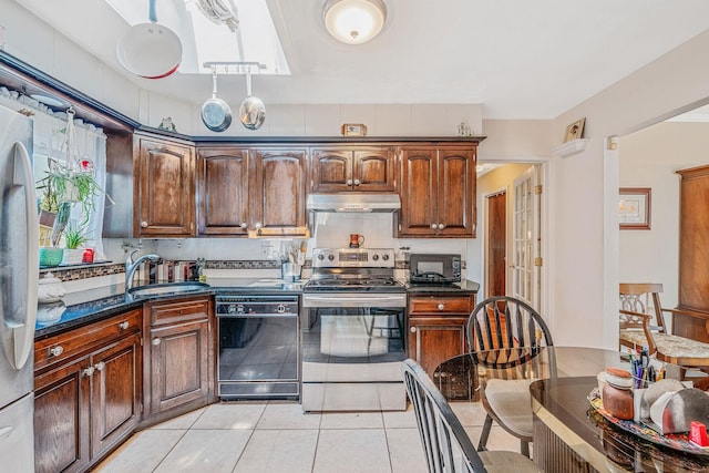 3324 Murdock Ave, Oceanside, NY 11572 - kitchen with dishwasher, stainless steel electric range oven, under cabinet range hood, light tile patterned floors, and dark stone counters
