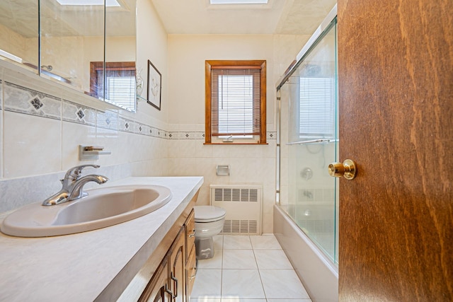 3324 Murdock Ave, Oceanside, NY 11572 - full bath with radiator, enclosed tub / shower combo, healthy amount of natural light, vanity, and tile walls