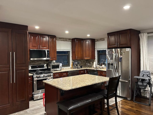 159-02 Cross Island Pkwy Unit 6-22, Whitestone, NY 11357 - kitchen with stainless steel appliances, wood finished floors, backsplash, a kitchen breakfast bar, and recessed lighting