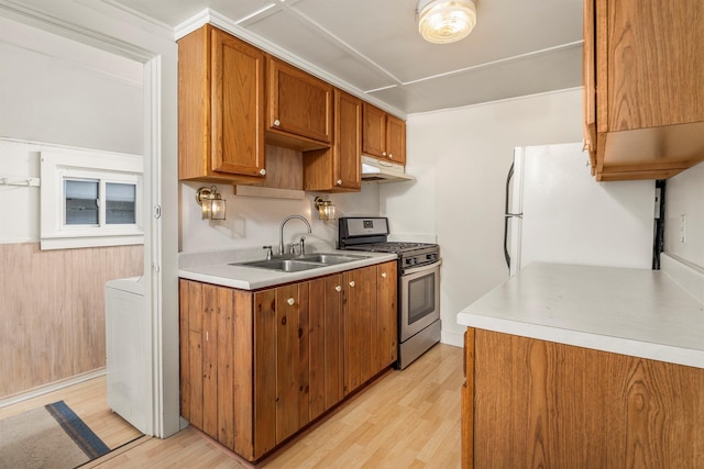 252 Ernest Rd, Millbrook, NY 12545 - kitchen featuring gas stove, freestanding refrigerator, under cabinet range hood, light wood-style flooring, and brown cabinets