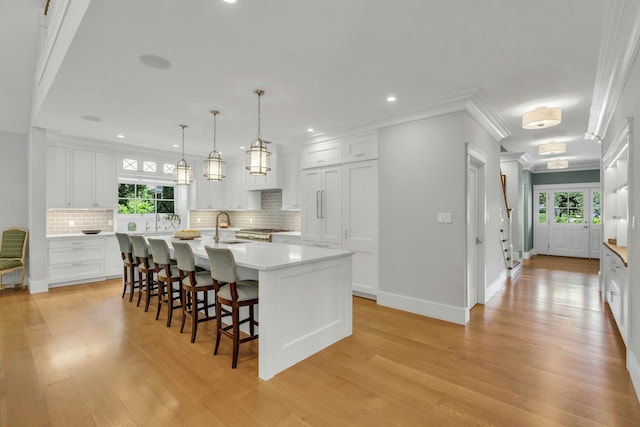 120 Cambon Ave, Saint James, NY 11780 - kitchen featuring light wood-type flooring, tasteful backsplash, ornamental molding, white cabinets, and recessed lighting