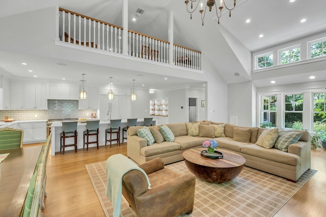 120 Cambon Ave, Saint James, NY 11780 - living area featuring a towering ceiling, light wood finished floors, recessed lighting, and a chandelier