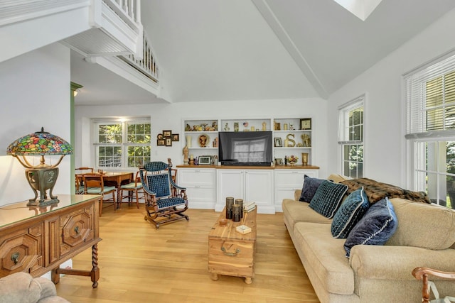 120 Cambon Ave, Saint James, NY 11780 - living room featuring light wood finished floors, vaulted ceiling, and healthy amount of natural light