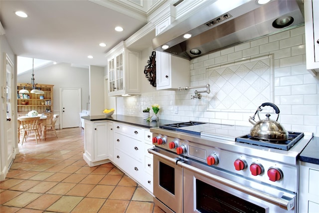 100 Gristmill Ln, Manhasset, NY 11030 - kitchen with double oven range, wall chimney exhaust hood, decorative backsplash, dark countertops, and recessed lighting