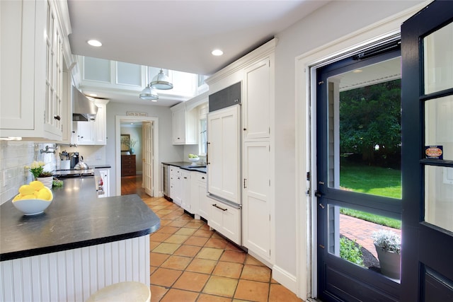100 Gristmill Ln, Manhasset, NY 11030 - kitchen featuring dark countertops, white cabinets, light tile patterned flooring, wall chimney exhaust hood, and recessed lighting