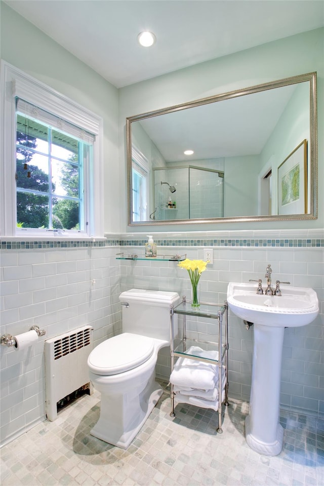 100 Gristmill Ln, Manhasset, NY 11030 - bathroom featuring radiator, tile walls, a shower stall, tile patterned flooring, and a wainscoted wall