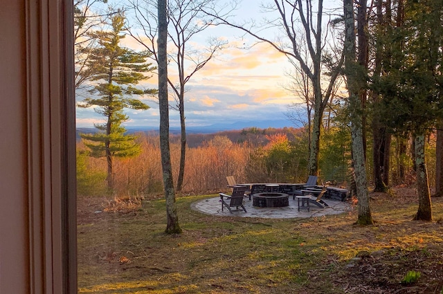 66 Beacon Hill Rd, Call Listing Agent, NY 12060 - yard at dusk with an outdoor fire pit, a patio area, and a wooded view