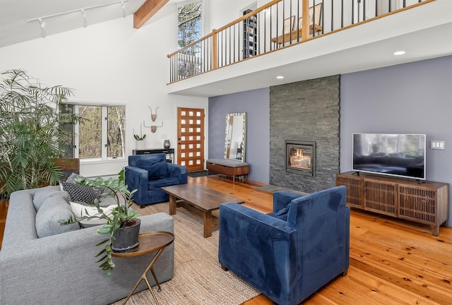 66 Beacon Hill Rd, Call Listing Agent, NY 12060 - living area with hardwood / wood-style flooring, rail lighting, a high ceiling, a stone fireplace, and healthy amount of natural light