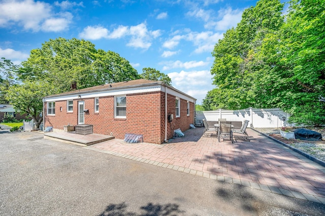 191 Laurel Rd, East Northport, NY 11731 - rear view of house with brick siding, a patio area, and outdoor dining area