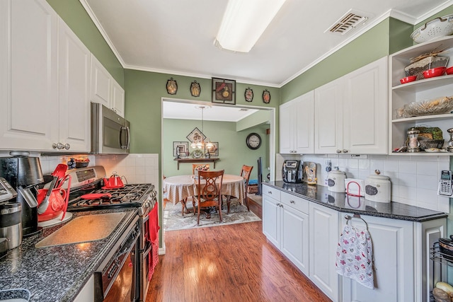 191 Laurel Rd, East Northport, NY 11731 - kitchen featuring appliances with stainless steel finishes, white cabinets, light wood-type flooring, tasteful backsplash, and ornamental molding