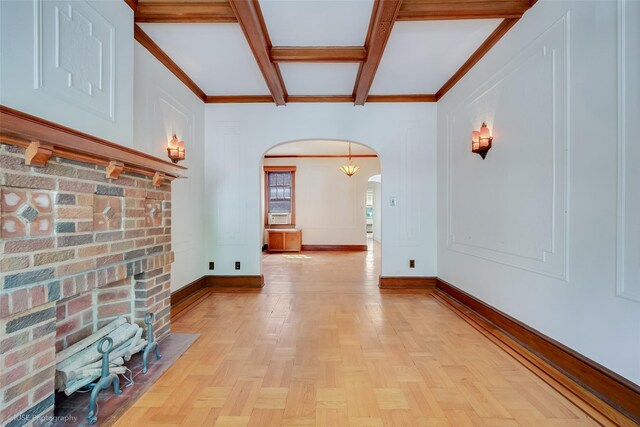 3916 51st St, Woodside, NY 11377 - unfurnished living room featuring arched walkways, beamed ceiling, coffered ceiling, crown molding, and a fireplace