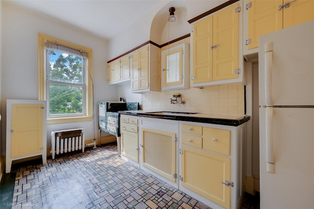3916 51st St, Woodside, NY 11377 - kitchen with freestanding refrigerator, dark countertops, tasteful backsplash, and radiator heating unit